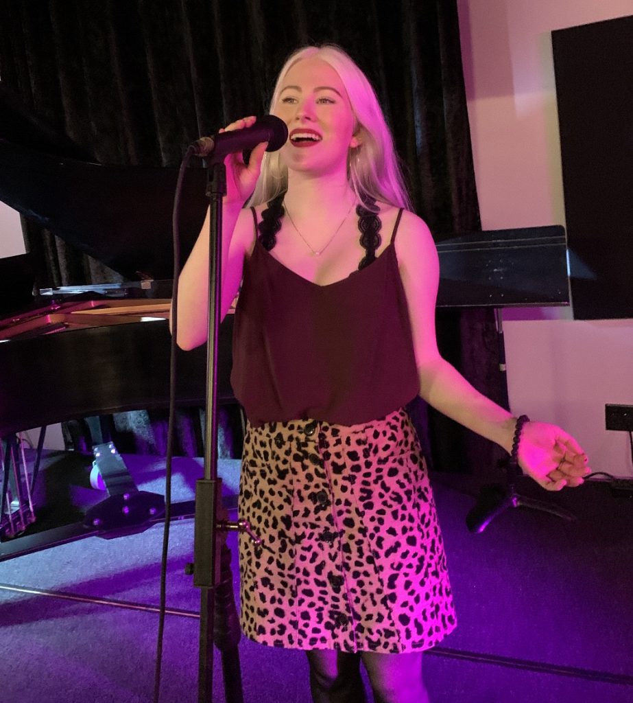 Sam H. sings into a microphone